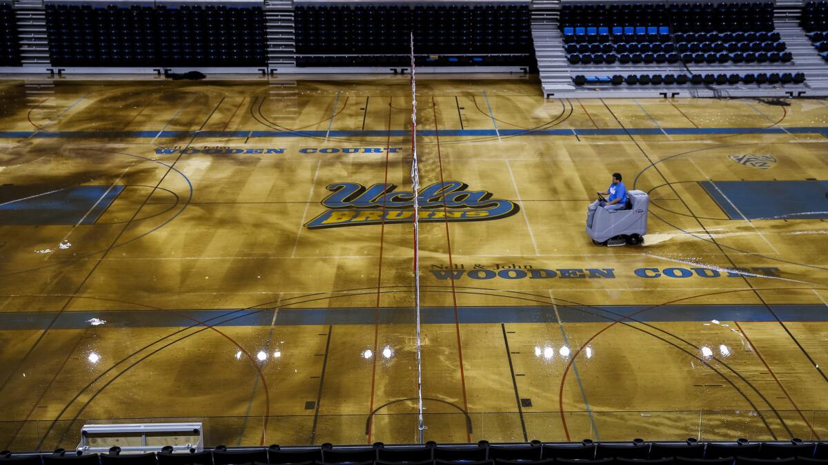 Water is removed from the floor of Pauley Pavilion on the UCLA campus Tuesday following a flood caused by a broken water main underneath Sunset Boulevard. Workers managed to remove all the water on the court Wednesday.