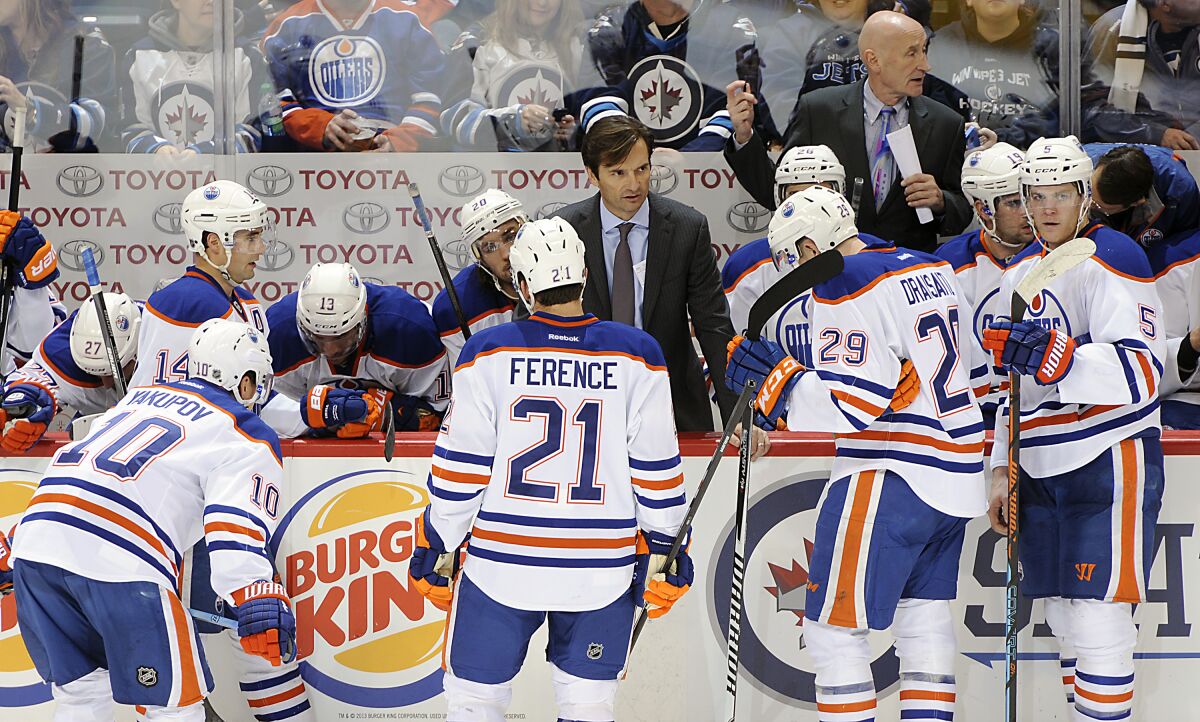 Edmonton Oilers coach Dallas Eakins speaks with his players during a timeout against the Winnipeg Jets in Dec. 2014.