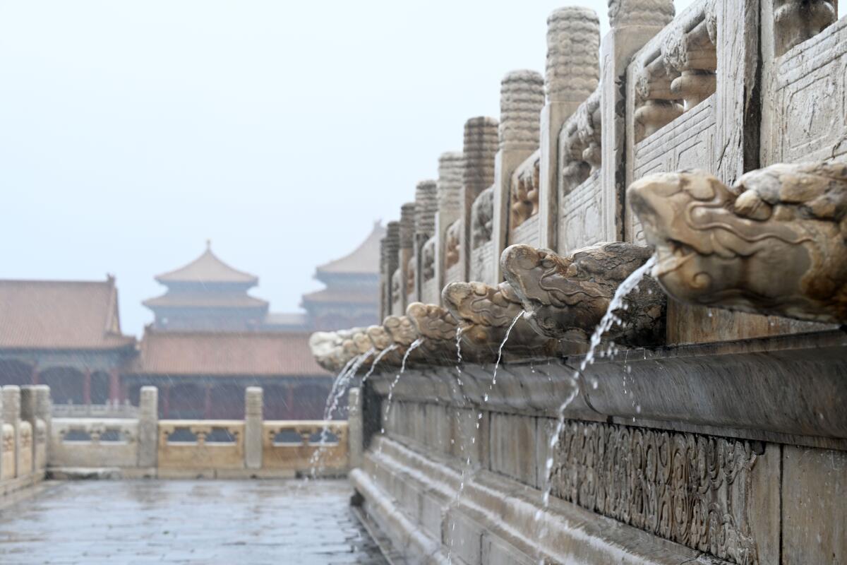 Rainwater flows from gargoyles inside the Forbidden City in Beijing, China.