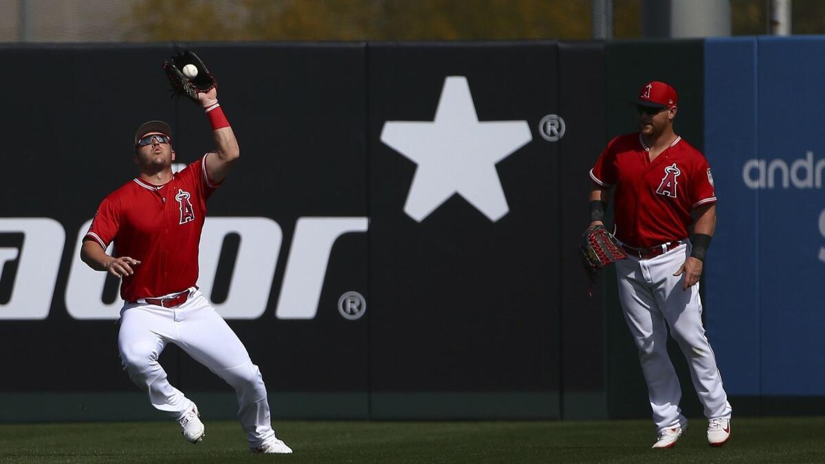 Angels center fielder Mike Trout, making a catch in front of right fielder Kole Calhoun in a spring-training game, called his teammate early Tuesday with news of his $426.5-million, 12-year deal with the team.