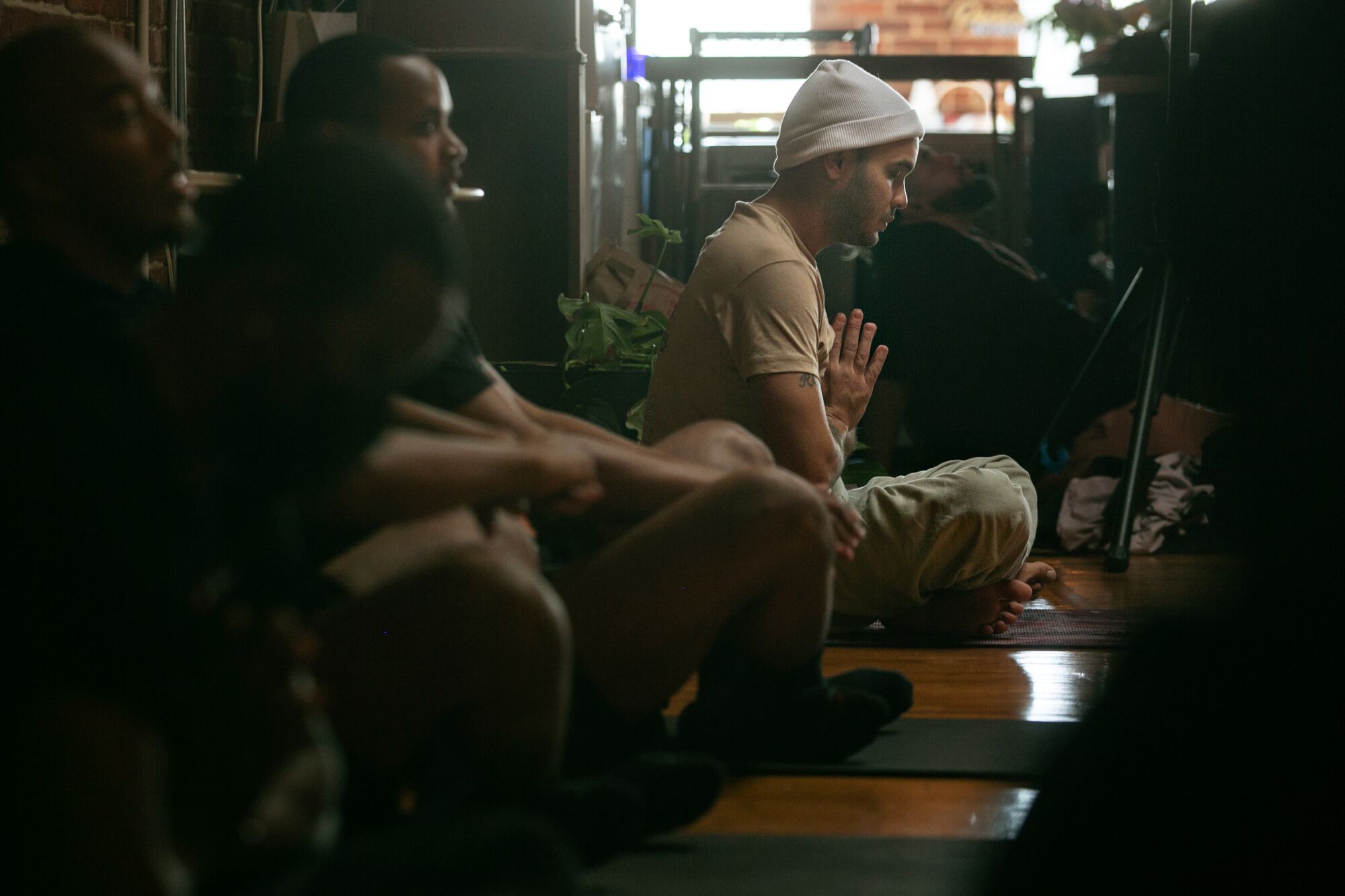 With his hands in prayer position, Bobby Brown meditates with other Black men.