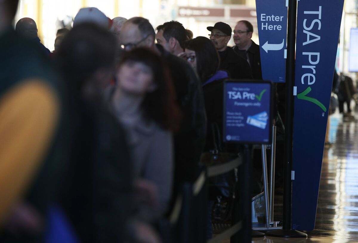 Travelers wait in a TSA Pre-Check line at Ronald Reagan Washington National Airport on Wednesday. There's a new online tool to help Pre-Check members find expedited lines.