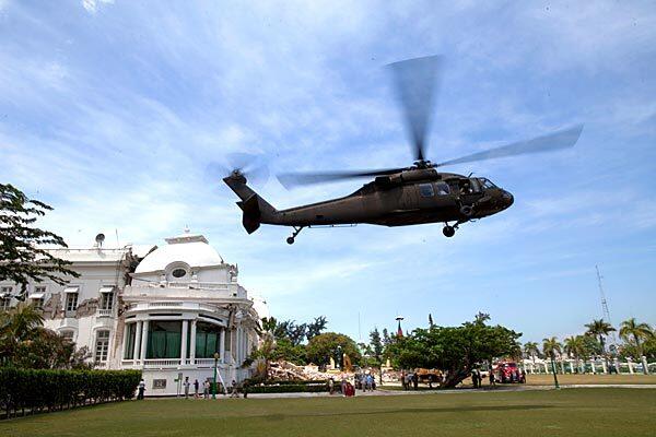 A U.S. Navy helicopter carrying First Lady Michelle Obama and Jill Biden, wife of Vice President Joe Biden, lands at the heavily damaged Presidential Palace in Port-au-Prince, for a surprise visit to the devastated Haitian capital.