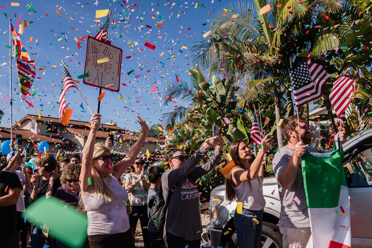Hundreds cheer Al Merritt after he rides his bicycle back home in Carlsbad on October 24.