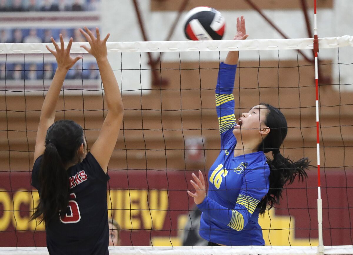 Fountain Valley's Myla Chi (16) hits over Ocean View blocker Mylynn Vo (6) for a point during a nonleague match on Monday.
