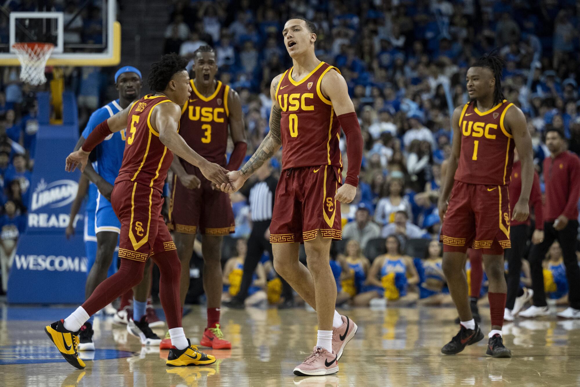 USC guard Kobe Johnson celebrates his basket against UCLA with guard Boogie Ellis and other teammates 