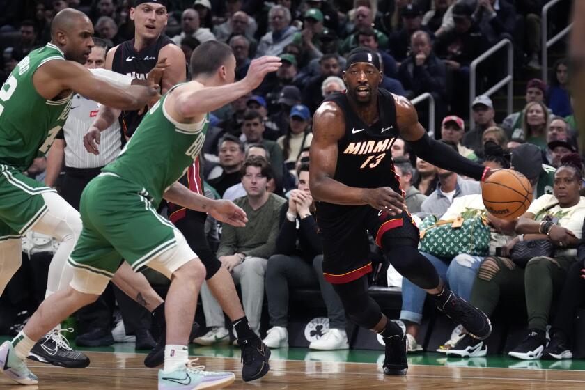 Miami Heat center Bam Adebayo, right, drives to the basket against the Boston Celtics during the second half of Game 2 of an NBA basketball first-round playoff series, Wednesday, April 24, 2024, in Boston. (AP Photo/Charles Krupa)
