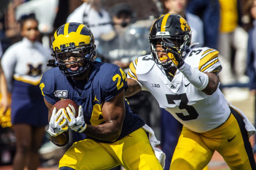 Michigan defensive back Lavert Hill (24) intercepts a pass intended for Iowa wide receiver Tyrone Tracy, Jr. (3) in the second quarter of an NCAA college football game in Ann Arbor, Mich., Saturday, Oct. 5, 2019. (AP Photo/Tony Ding)