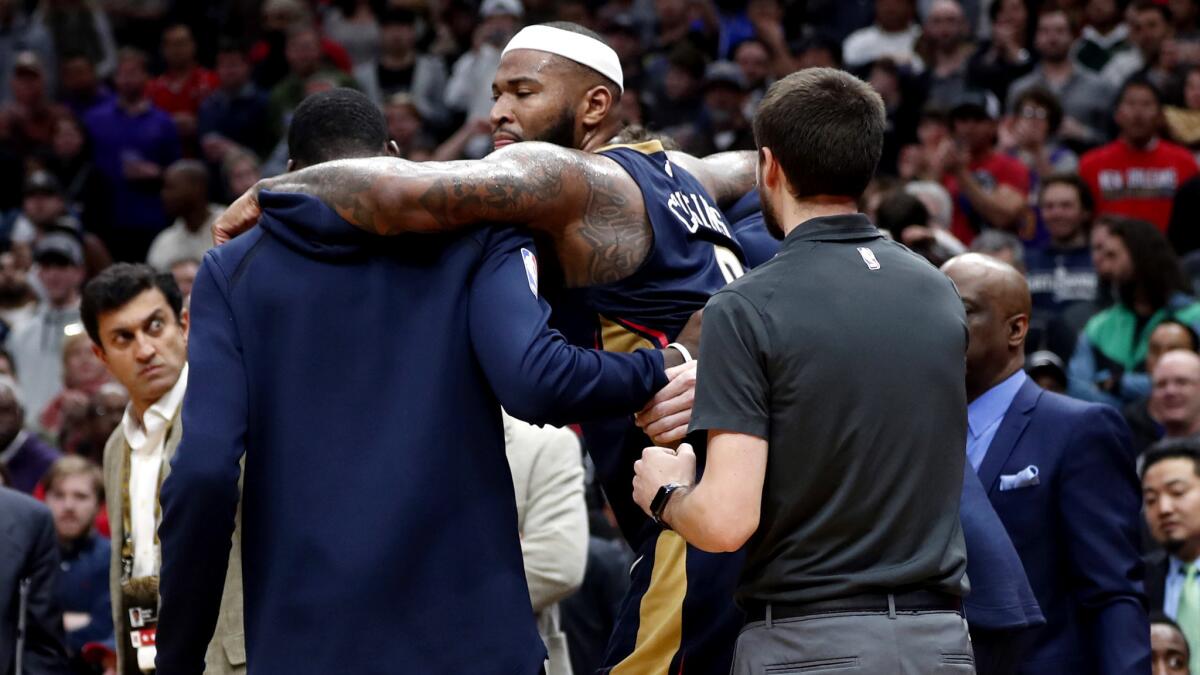 New Orleans Pelicans center DeMarcus Cousins is helped off the court after injuring his left Achilles tendon in New Orleans on Friday.