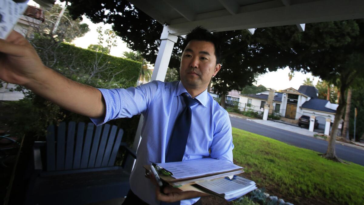 Los Angeles City Council candidate David Ryu leaves a campaign flier at a house in December.