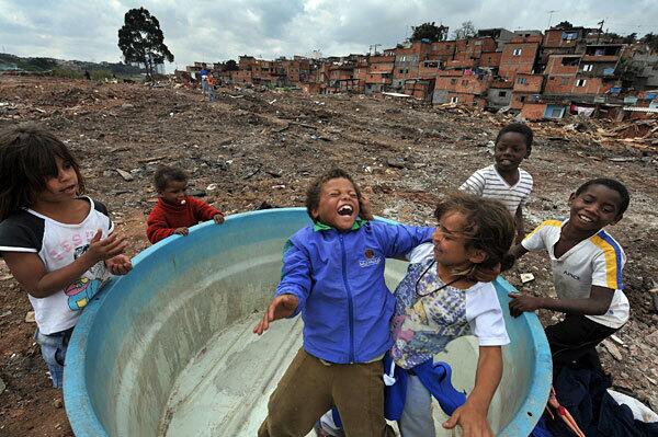 Brazilian children play inside an abandoned water tank on the land from which they were evicted on southern outskirts of Sao Paulo, Brazil. The children and other slum dwellers were living on property belonging to a bus company.