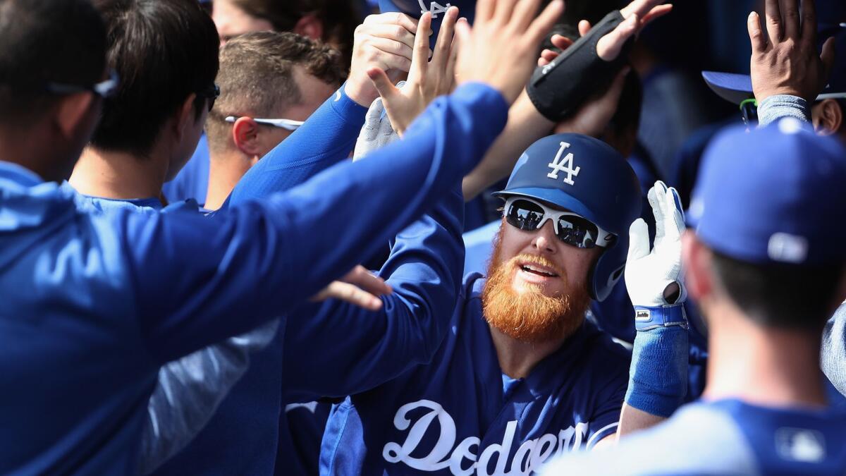 Justin Turner is congratulated by his Dodgers teammates after hitting a two-run home run against the Chicago Cubs during an exhibition game on Feb. 25.