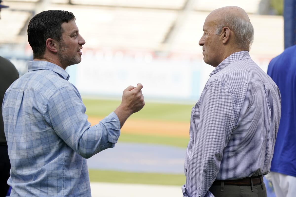 Andrew Friedman, left, and Stan Kasten talk before Game 1 of the NLDS between the Dodgers and the San Diego Padres.