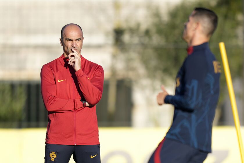 Portugal coach Roberto Martinez watches Cristiano Ronaldo, right, during a Portugal soccer team training session in Oeiras, outside Lisbon, Tuesday, March 21, 2023. Portugal will play Liechtenstein Thursday in a Euro 2024 qualifying match in Lisbon, the first game under the new team head coach Roberto Martinez. (AP Photo/Armando Franca)