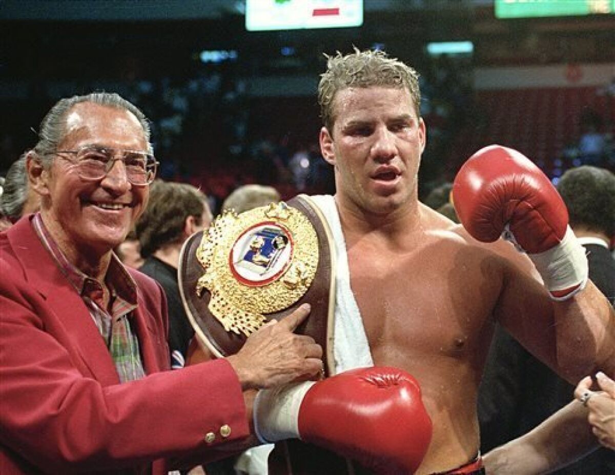 FILE - In this June 7, 1993 file photo, newly crowned WBO heavyweight champion Tommy Morrison receives his championship belt after defeating George Foreman in Las Vegas, Nev. Morrison, a former heavyweight champion who gained fame for his role in the movie "Rocky V," has died. He was 44. Morrison's former manager, Tony Holden says his longtime friend died Sunday night, Sept. 1, 2013, at a Nebraska hospital. (AP Photo/Nick Ut, File)