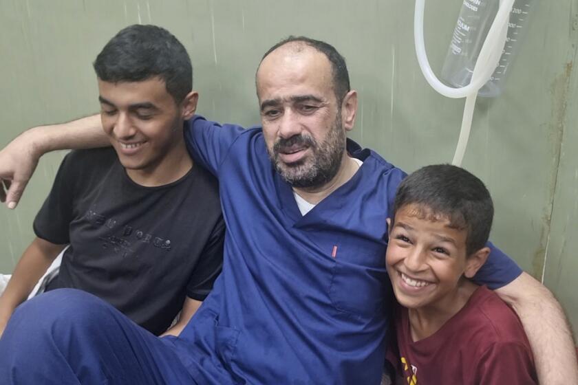 This video grab shows Mohammed Abu Selmia, the director of Gaza's main hospital, who was detained by Israeli forces in November, sitting with his family after his release, along with other detainees, at a hospital in Khan Younis, Gaza Strip on Monday, July 1, 2024. Israel released the director of Gaza's main hospital on Monday after holding him for seven months without charge or trial over allegations the facility had been used as a Hamas command center. He said he and other detainees were held under harsh conditions and tortured. (AP Photo/Mohammad Jahjouh)