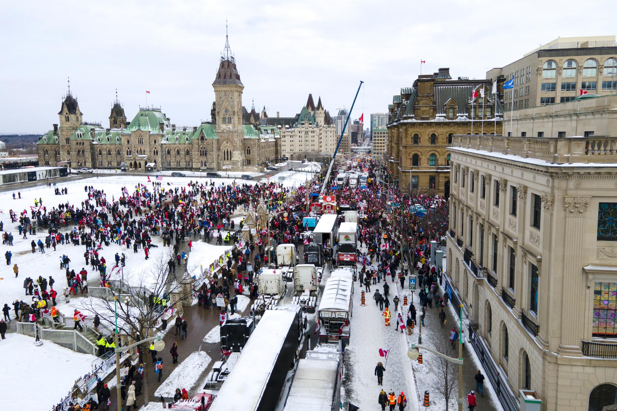 Trucks clog a street in a snowy city 