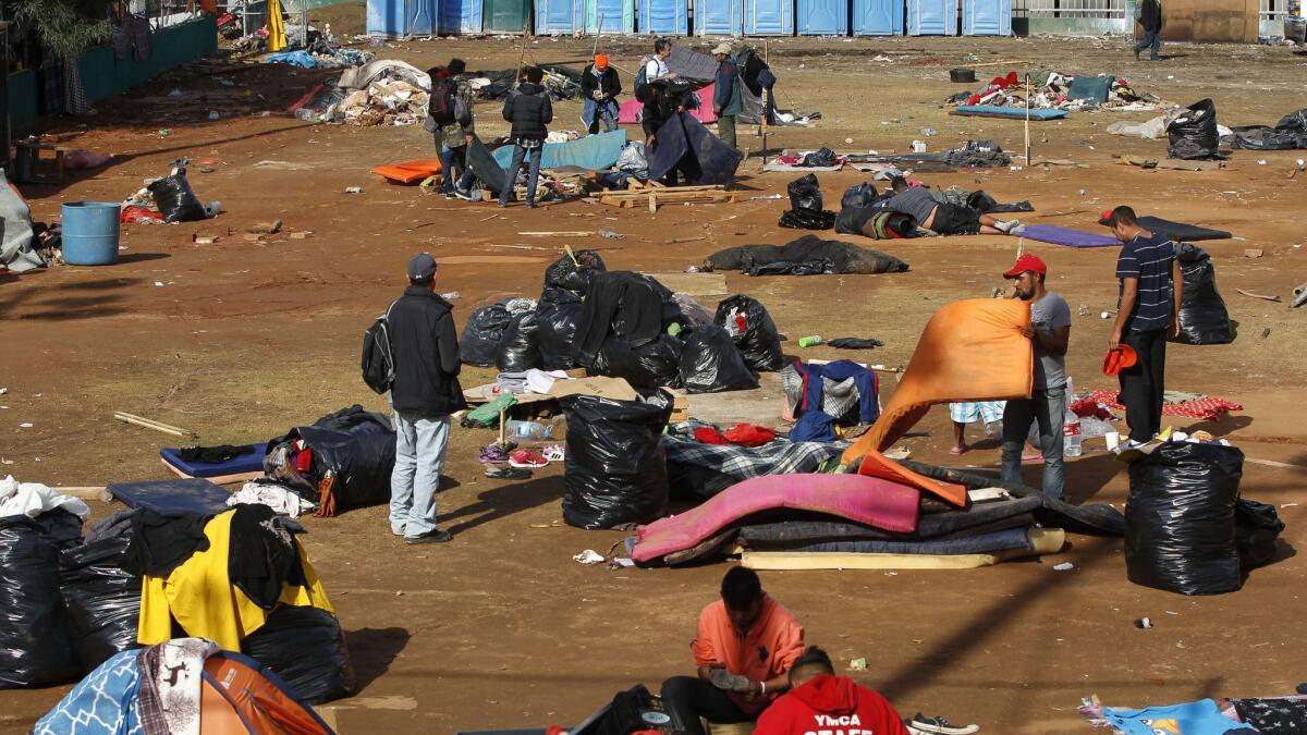 The remaining Central American migrants pack up their belongings on a baseball field at the Benito Juarez sports complex in Tijuana. Overcrowding and rain deteriorated conditions in the camp before officials found another place to house the migrants.