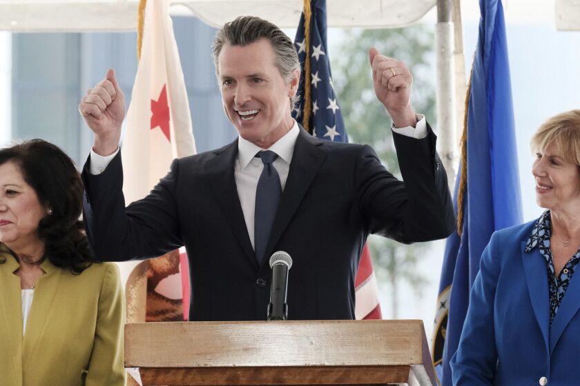 Gov. Gavin Newsom reacts during a news conference while flanked by L.A. County Supervisor Hilda Solis,left and Chair of the Los Angeles County Board of Supervisors Janice Hahn at Rancho Los Amigos National Rehabilitation Center in Downey, Calif. on Wednesday, April 17, 2019. Newsom says the state will partner with Los Angeles County in its effort to bring down prescription drugs prices. Newsom directed state agencies earlier this year to begin buying drugs in bulk and using that leverage to negotiate lower prices. The idea remains in planning stages, with the first purchases not expected until later this year. Newsom says patients and taxpayers are being gouged by soaring drug prices driven by corporate greed. (AP Photo/Richard Vogel)
