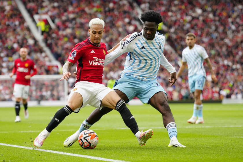 Manchester United's Antony, left, challenges for the ball with Nottingham Forest's Ola Aina during the English Premier League soccer match between Manchester United and Nottingham Forest at the Old Trafford stadium in Manchester, England, Saturday, Aug. 26, 2023. (AP Photo/Jon Super)