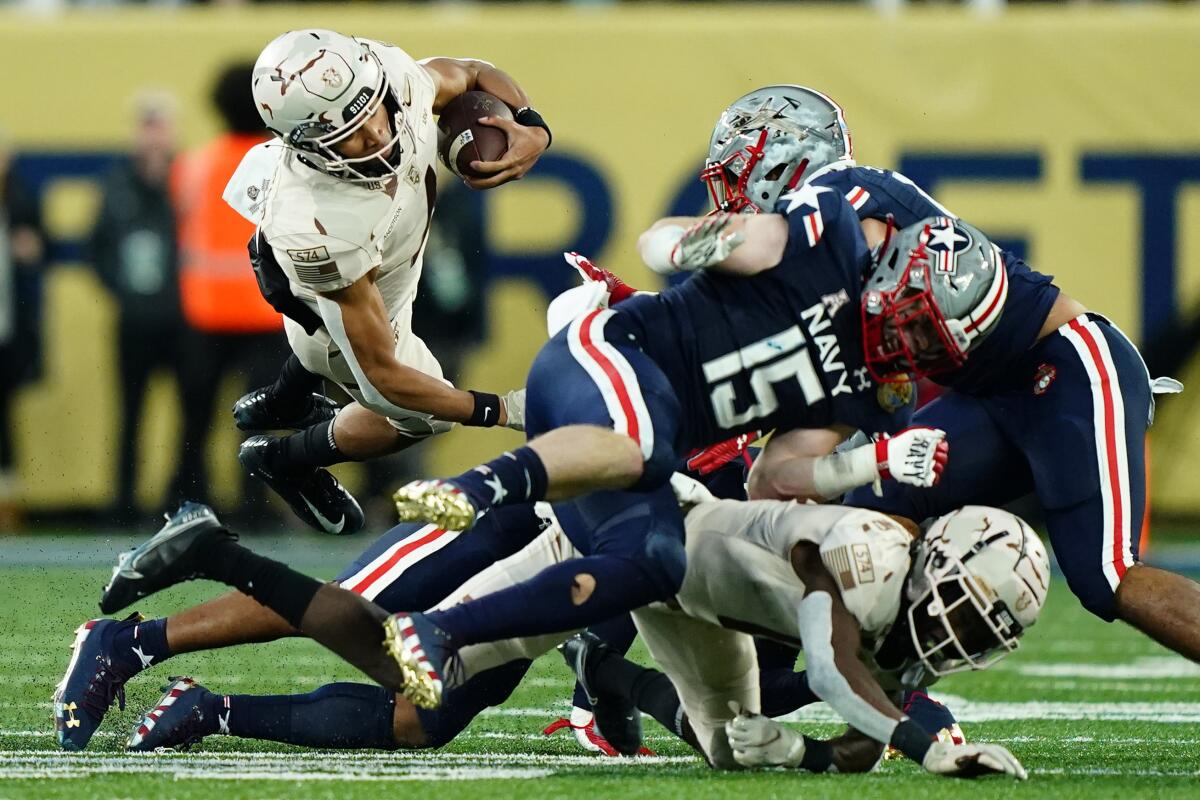 Army quarterback Christian Anderson is tripped up as he runs against Navy on Saturday in East Rutherford, N.J.