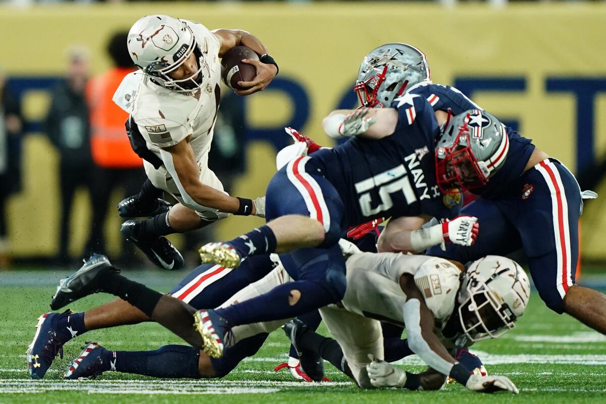 Army quarterback Christian Anderson is tripped up as he runs against Navy on Saturday in East Rutherford, N.J. 