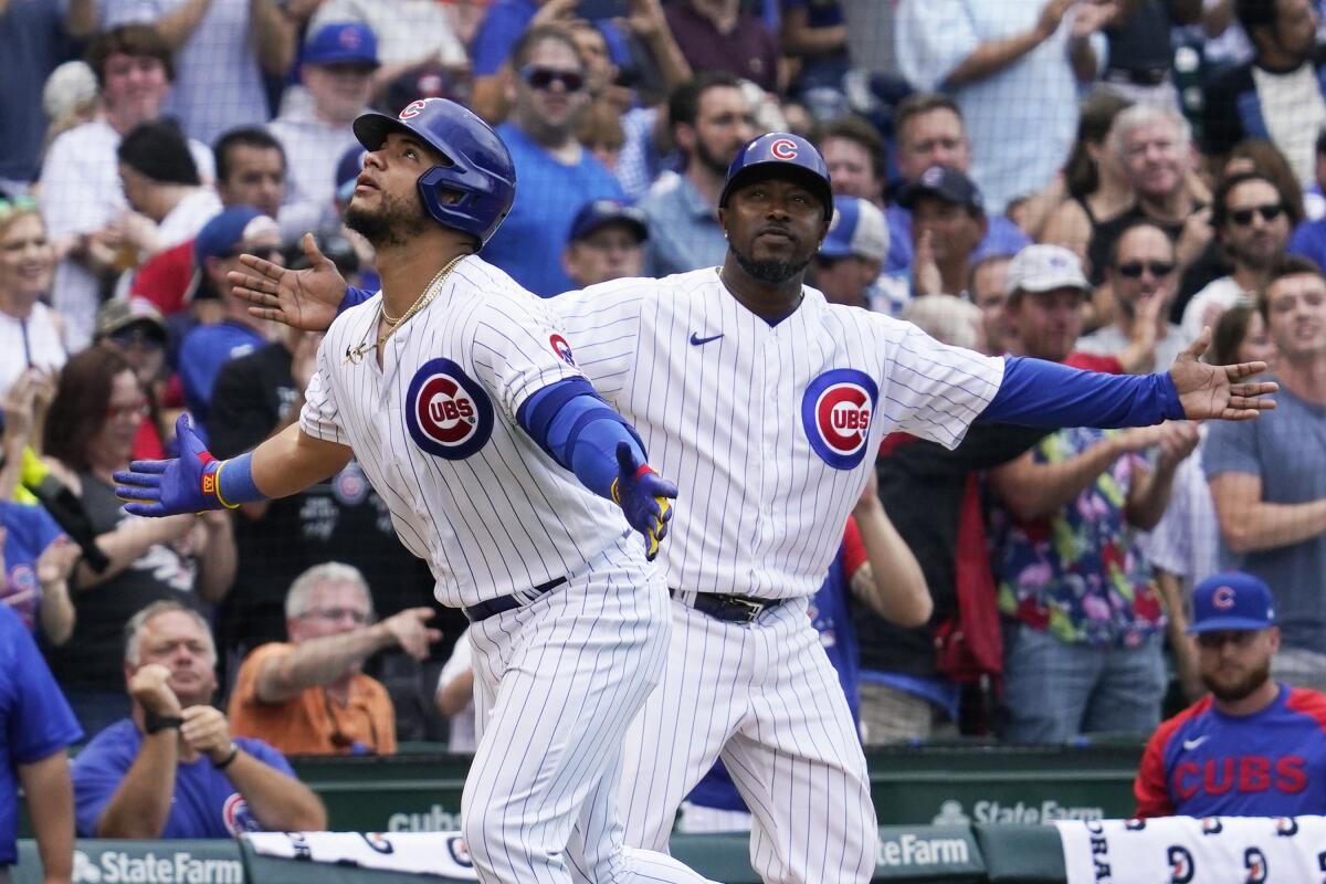 Chicago Cubs' Willson Contreras, left, and third base coach Willie Harris react after Contreras hit a two-run home run during the fifth inning of a baseball game against the Milwaukee Brewers in Chicago, Saturday, Aug. 20, 2022. (AP Photo/Nam Y. Huh)