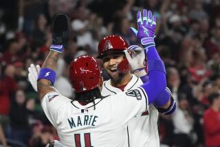 El cubano Lourdes Gurriel Jr. festeja con el dominicano Ketel Marte, su compañero en los Diamondbacks de Arizona, luego de batear un jonrón de dos carreras en el juego del jueves 28 de marzo de 2024 ante los Rockies de Colorado (AP Foto/Ross D. Franklin)