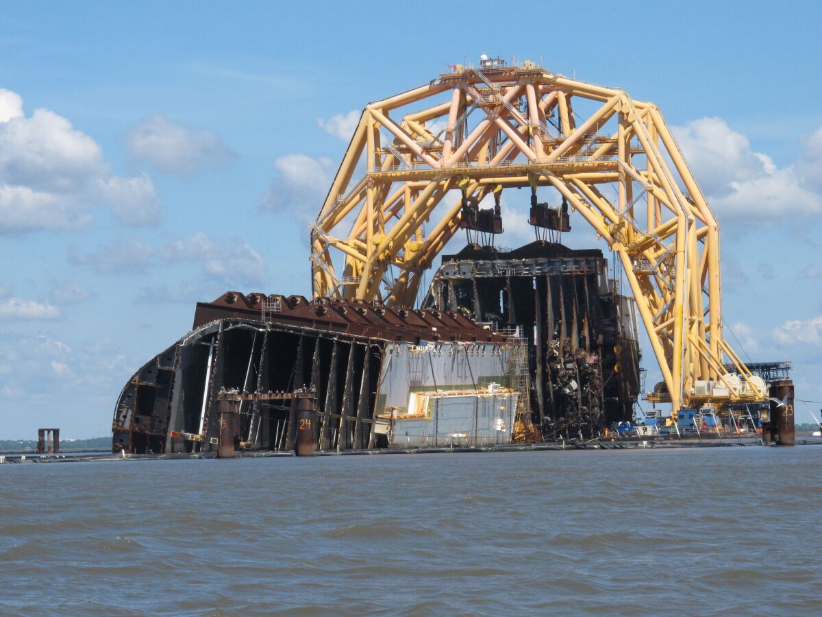 FILE - In this Monday, April 26, 2021, file photo, a towering crane pulls the engine room section away from the remains of the capsized cargo ship Golden Ray, offshore of St. Simons Island, Ga. A large amount of oil has escaped a barrier after it was released while crews were dismantling the overturned cargo ship along the Georgia coast, the Coast Guard said Thursday, July 1, 2021. (AP Photo/Russ Bynum, File)