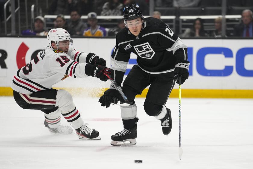 Chicago Blackhawks right wing Joey Anderson (15) defends against Los Angeles Kings defenseman Jordan Spence (21) during the first period of an NHL hockey game Thursday, April 18, 2024, in Los Angeles. (AP Photo/Ashley Landis)