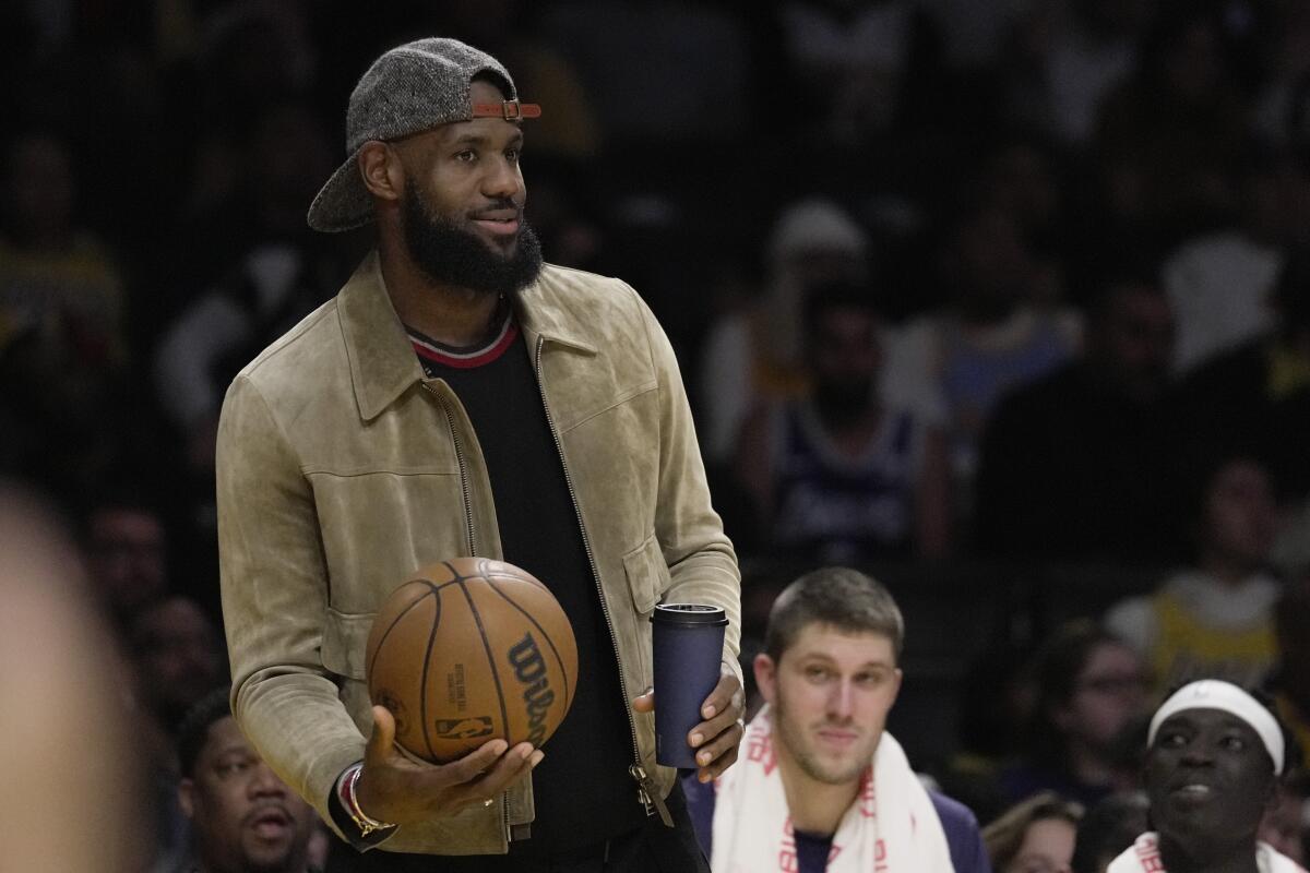 Lakers forward LeBron James holds a ball on the sideline against the Brooklyn Nets.