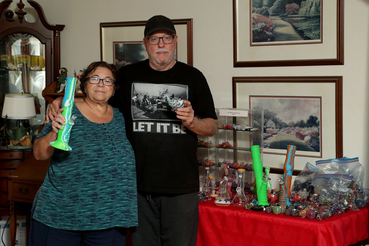 Jeanine and Mike Robbins, owners of Paradise Cigars, with glassware they are forbidden from selling at the O.C. fairgrounds.