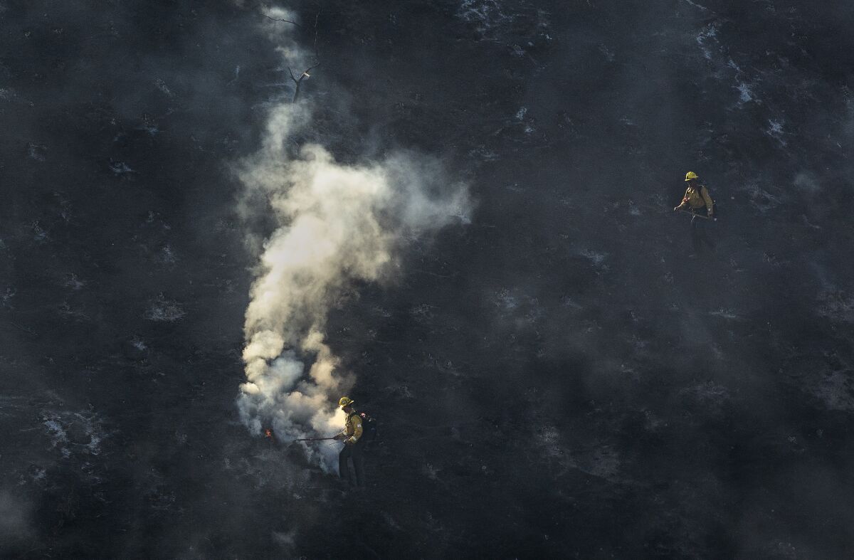 Two firefighters are seen next to smoke