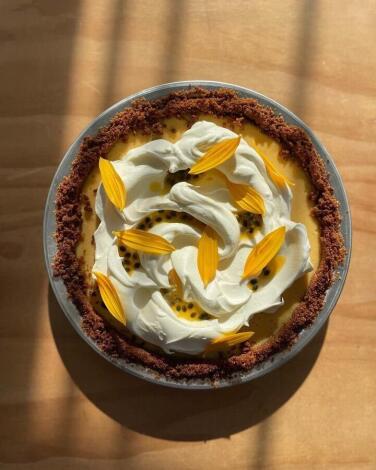 A Key lime passion fruit pie topped with yellow flower petals from Sasha Piligian's May Microbakery