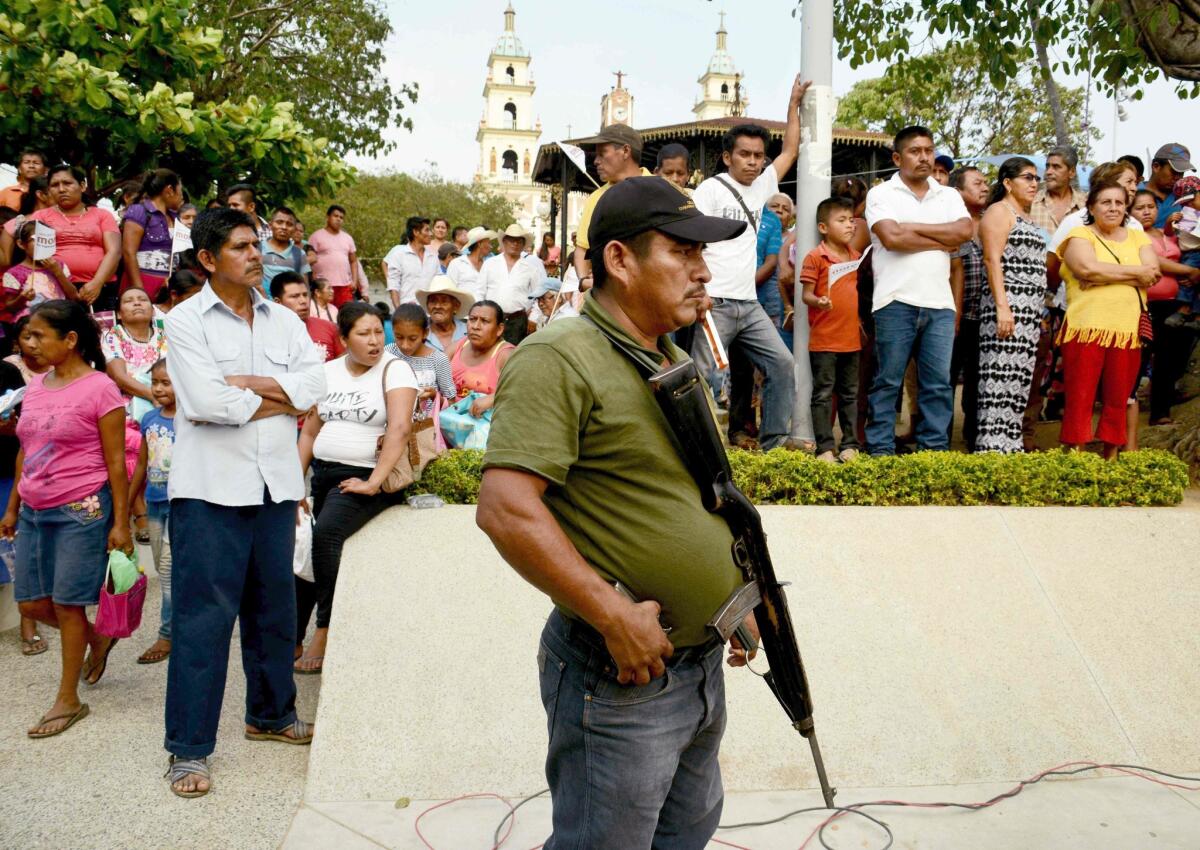 Un miembro de las guardias comunitarias en el estado de Guerrero, vigila durante un evento de campaña de Nestora Salgado, de MORENA. Más de 120 candidatos han sido asesinados en todo el territorio mexicano.