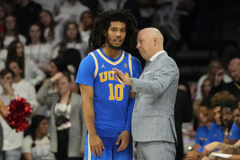 UCLA guard Tyger Campbell (10) talks to head coach Mick Cronin during the first half of an NCAA college basketball game against Arizona, Saturday, Jan. 21, 2023, in Tucson, Ariz. (AP Photo/Rick Scuteri)