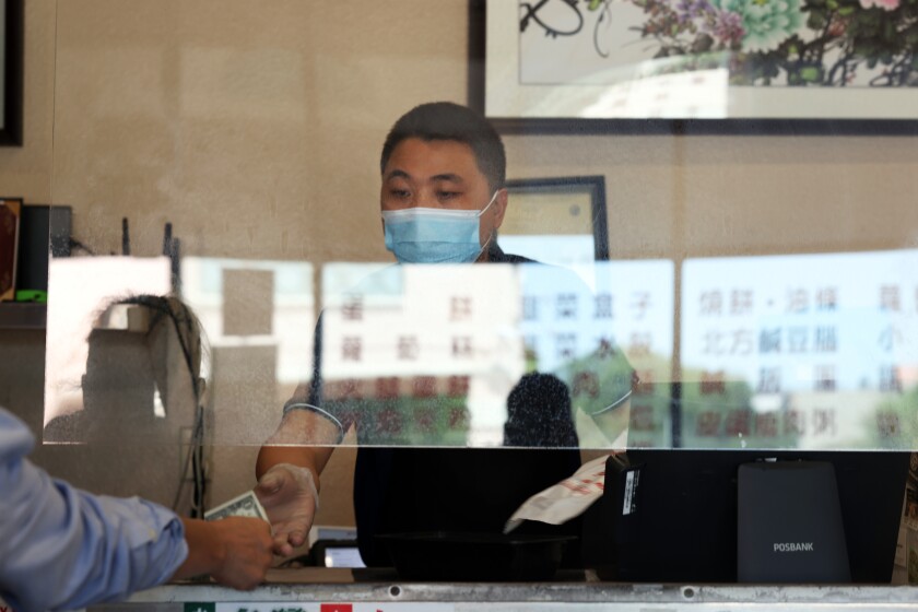 Manager Andrew Zhang gives change to a customer at YungHo cafe.