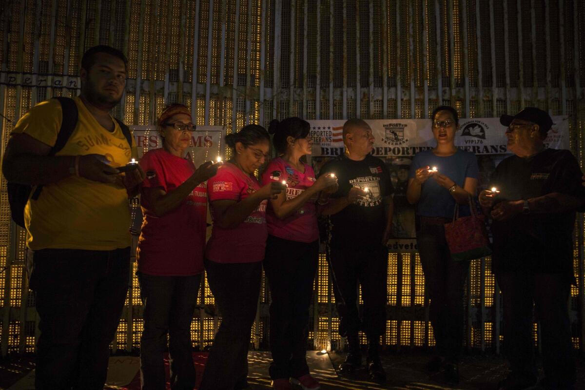 Activists pray for the continuation of DACA during a protest at the border wall in Tijuana on Monday.