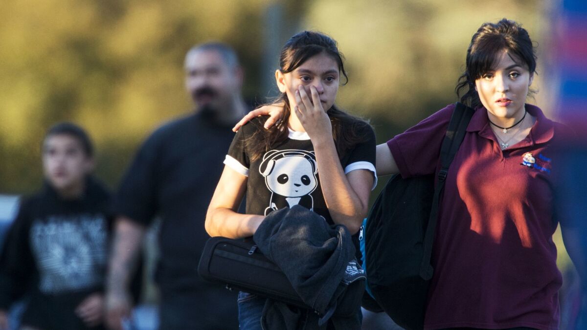 Parents evacuate their children after Slauson Middle School was placed on lockdown during a shooting at the intersection of Orange Avenue and Fourth Street in Azusa.