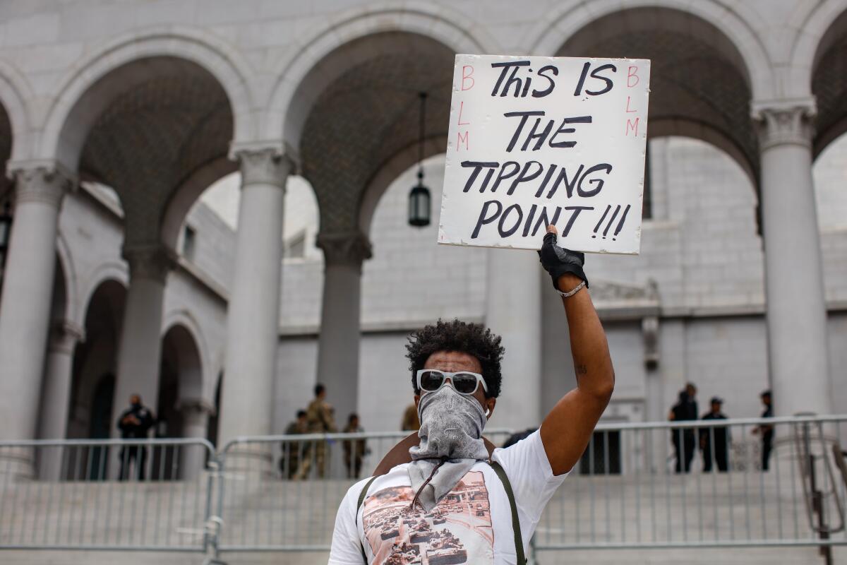 Protester LMek Bitul holds up a sign outside L.A. City Hall on June 5. 