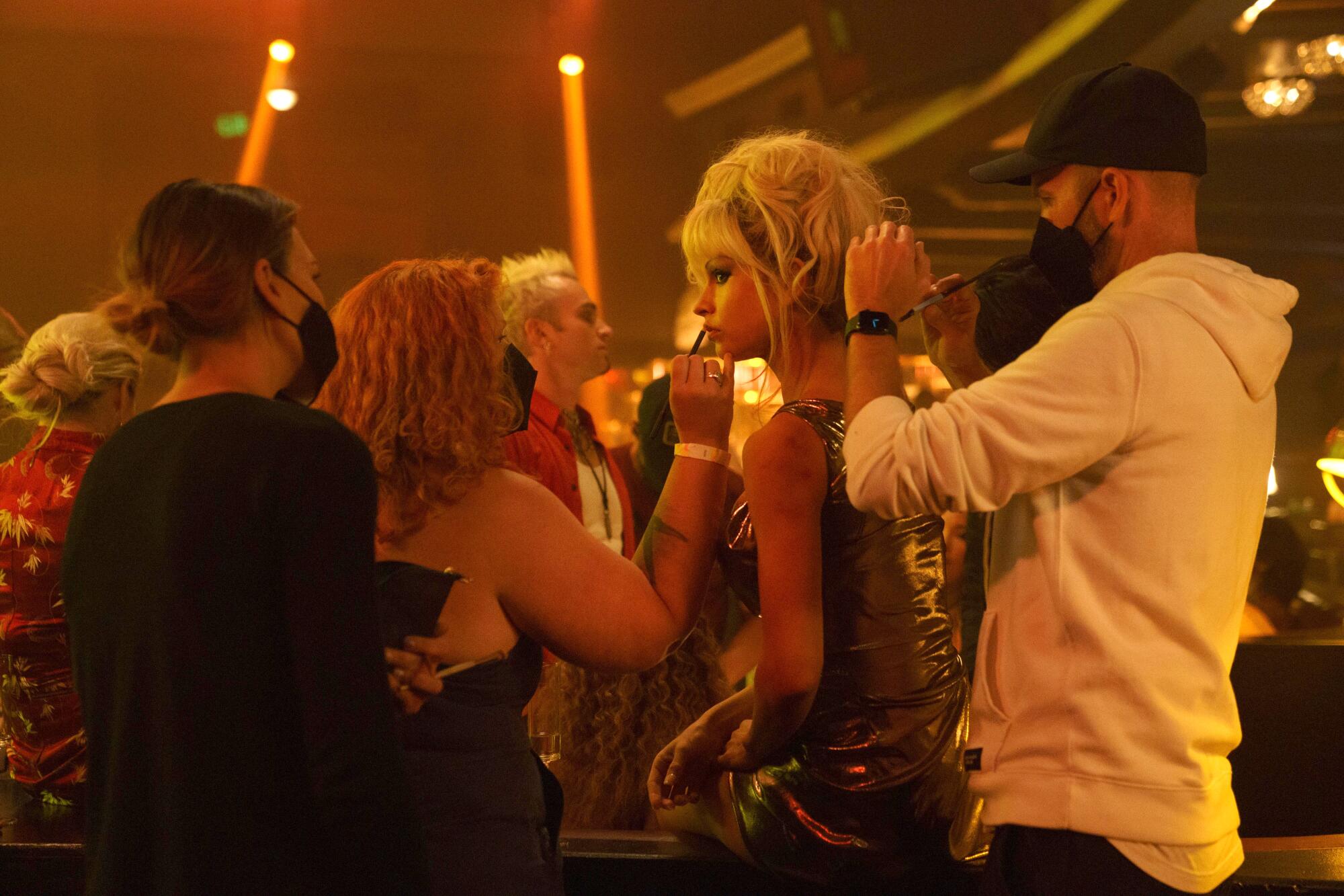 Hair and makeup team members touch-up Lily James' lips and wig on the set of "Pam & Tommy."