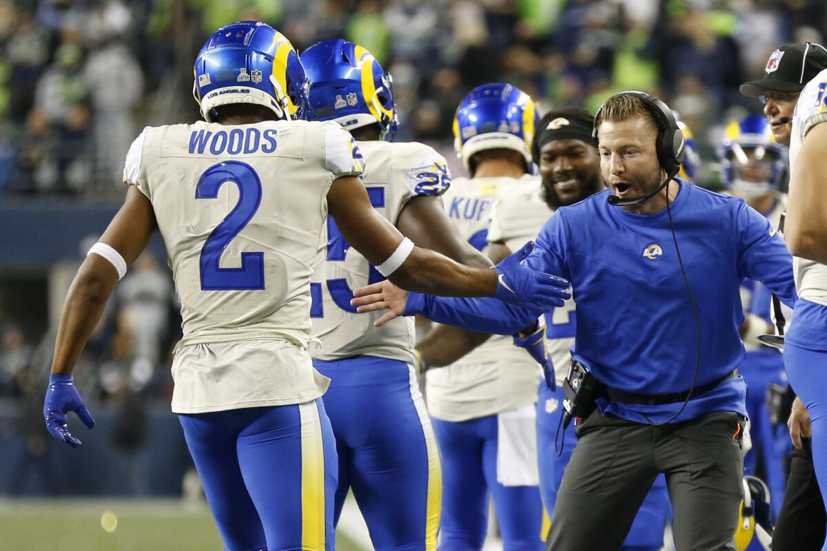 Los Angeles Rams head coach Sean McVay, right, greets Robert Woods (2) and running back Sony Michel (25), second from left, after Michel scored a touchdown against the Seattle Seahawks during the second half of an NFL football game, Thursday, Oct. 7, 2021, in Seattle. (AP Photo/Craig Mitchelldyer)