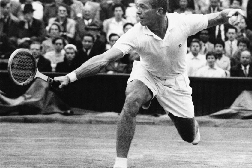 FILE - Tony Trabert makes a return to Kurt Nielson on center court at Wimbledon, in this July 1, 1955, file photo. Trabert won, 6-3, 7-5, 6-1. Trabert, a five-time Grand Slam singles champion and former No. 1 player who went on to successful careers as a Davis Cup captain, broadcaster and executive, has died. He was 90 years old. The Tennis Hall of Famer's death Wednesday night, Feb. 3, 2021, at his home in Ponte Vedra Beach, Florida, was confirmed by his daughter, Brooke Trabert Dabkowski. (AP Photo/FIle)