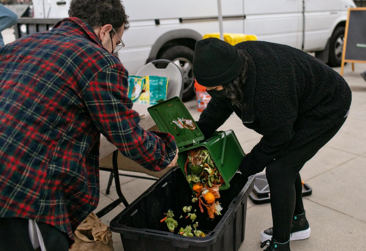 Food waste is being weighed by Kevelin Barcenas-Garcia Angeleno at a booth at a farmers market. 