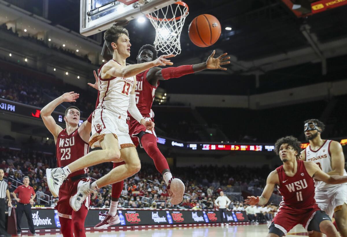 USC guard Drew Peterson makes a leaping pass in front of Washington State forward Mouhamed Gueye.