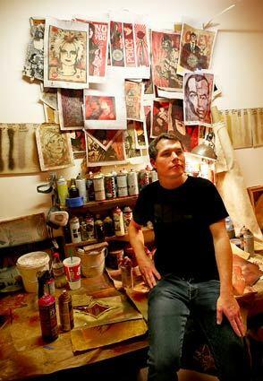 Artist Shepard Fairey sits in a re-creation of his workshop at the opening of his show "Imperfect Union" on Nov. 30 at the Merry Karnowsky Gallery in Los Angeles.