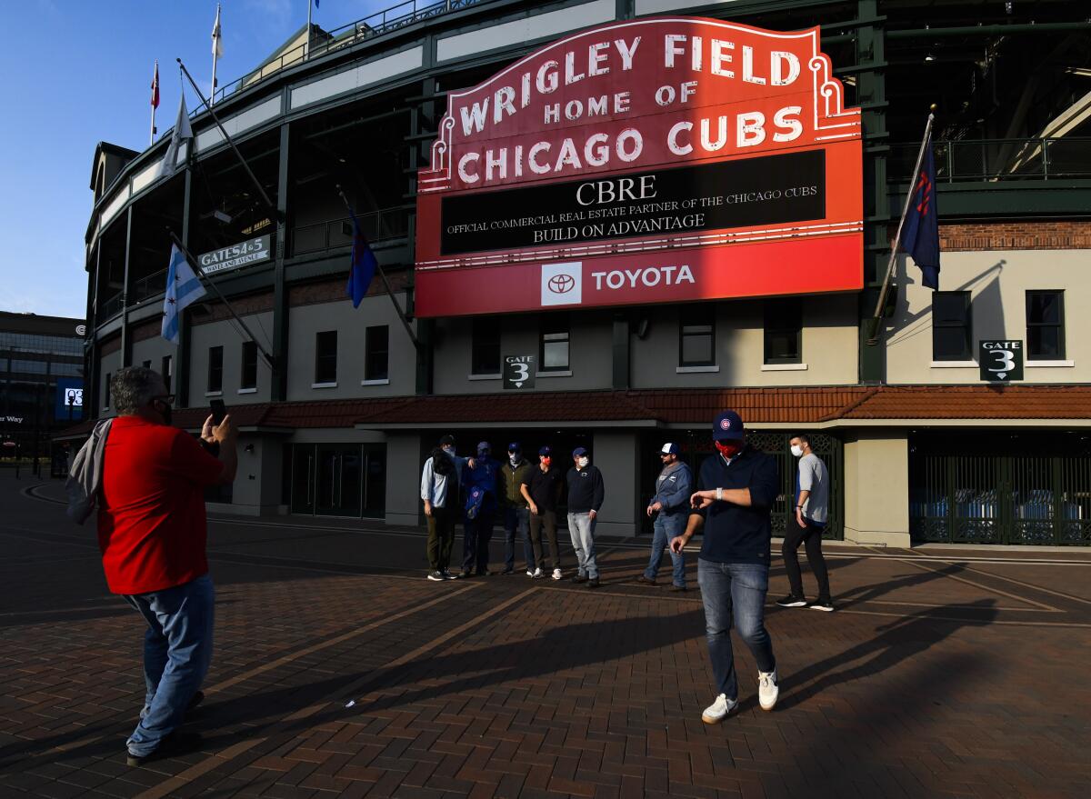 Aficionados se toman fotos frente al Wrigley Field de los Cachorros de Chicago