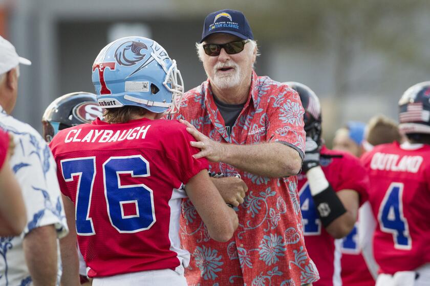 Brethren Christian High coach Pat McInally, coaching the South team, encourages Corona del Mar High defensive lineman Bryce Claybaugh (76) after the he helped the defense make a stop against the North team in the first half of the 58th annual Orange County All-Star Classic on Friday at LeBard Stadium in Costa Mesa. (Kevin Chang/ Daily Pilot)