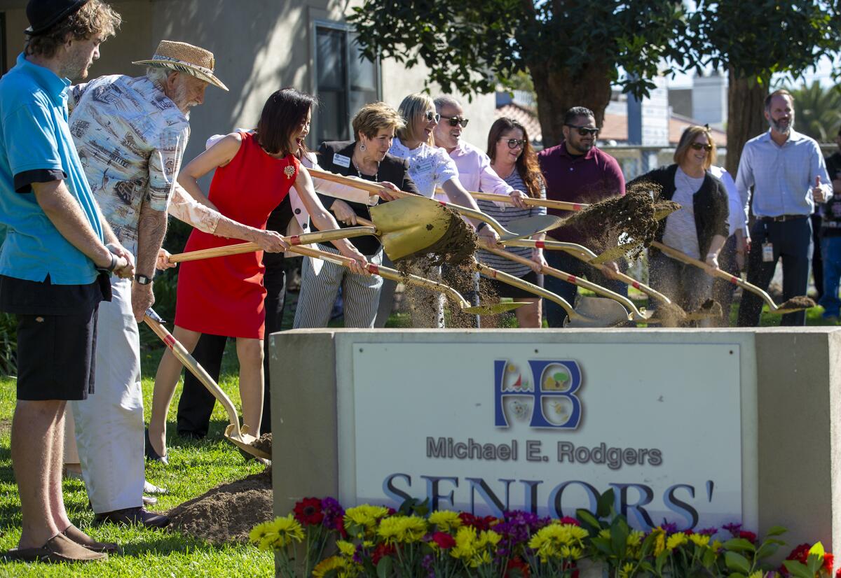 Local dignitaries throw a shovel full of dirt at a groundbreaking at the Rodgers Seniors' Center.