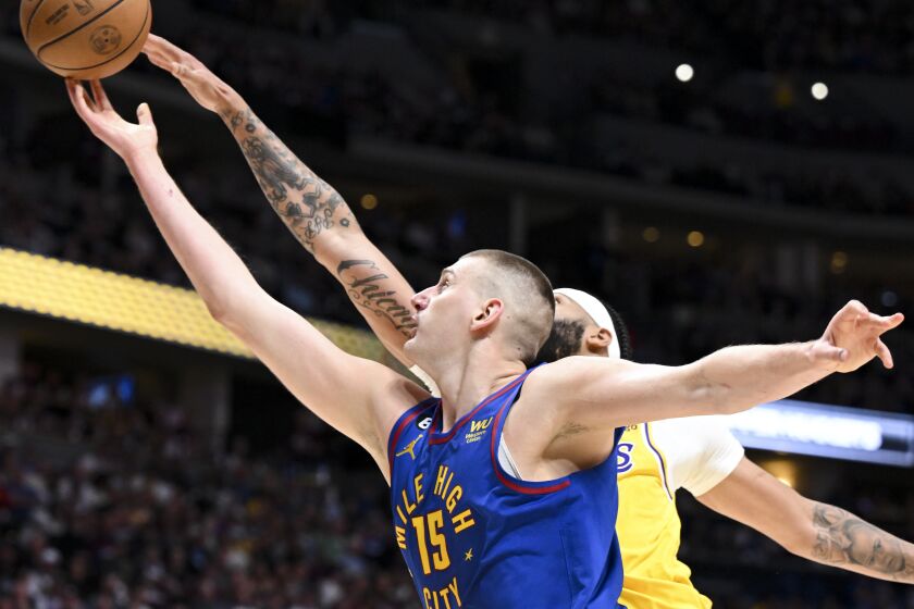 DENVER, CO - MAY 16: Denver Nuggets center Nikola Jokic, front, shoots while pressured by Los Angeles Lakers forward Anthony Davis during the first half of game one in the NBA Playoffs Western Conference Finals at Ball Arena on Tuesday, May 16, 2023 in Denver, CO. (Wally Skalij / Los Angeles Times)